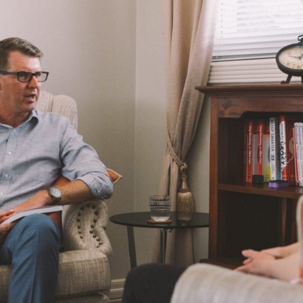 man talking to woman on chairs