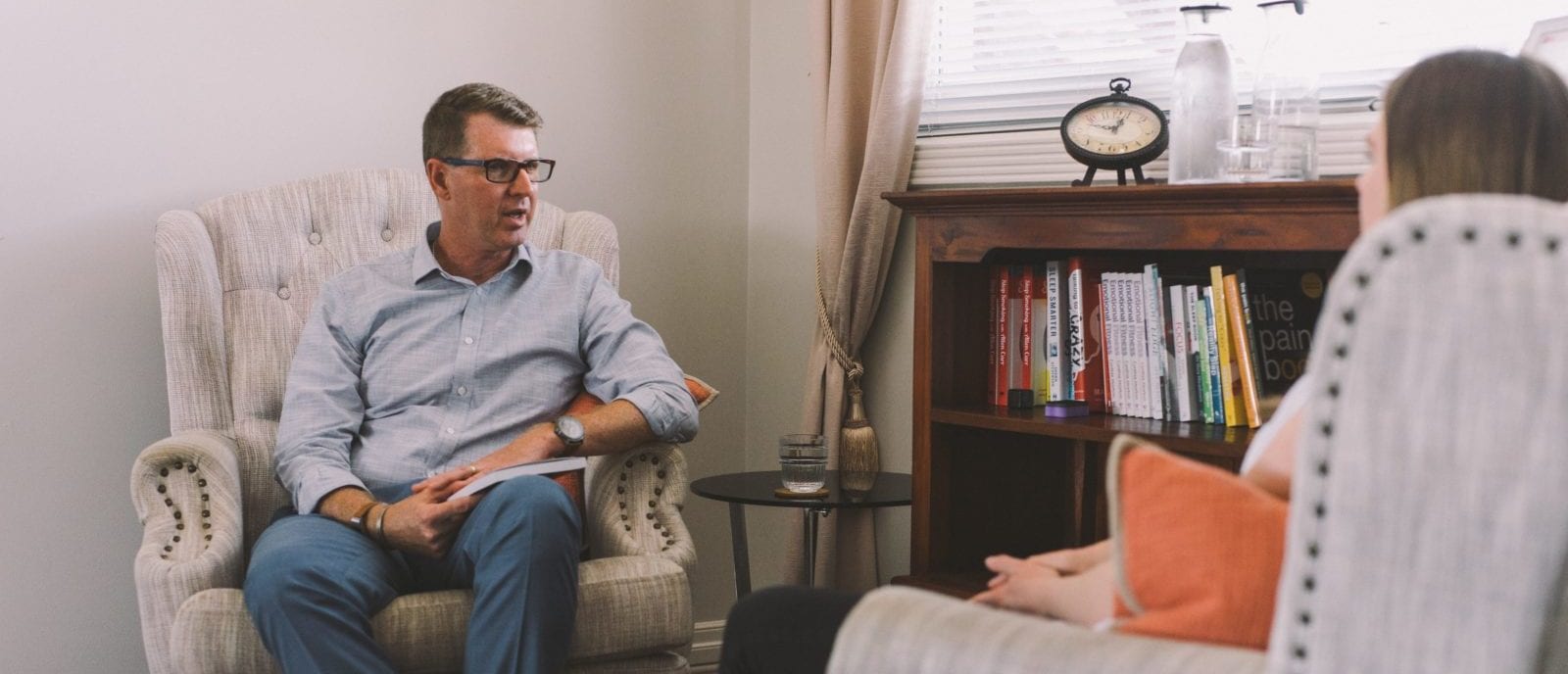 man talking to woman on chairs
