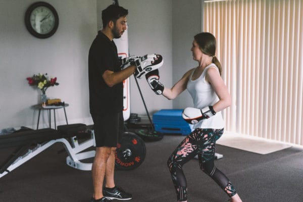 Woman boxing with trainer