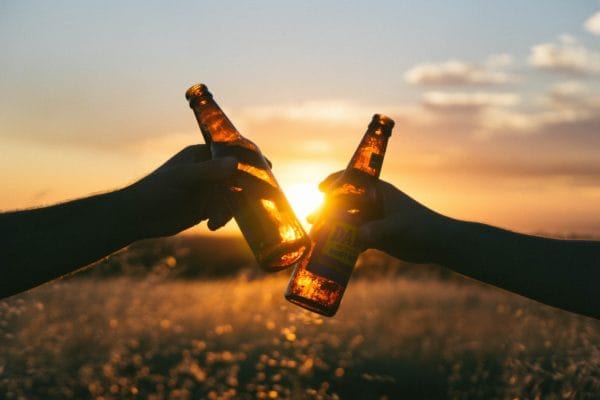 People cheers beer bottles to help them relax