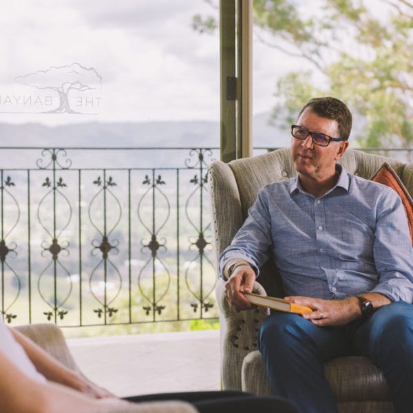 woman and man sitting on chairs talking