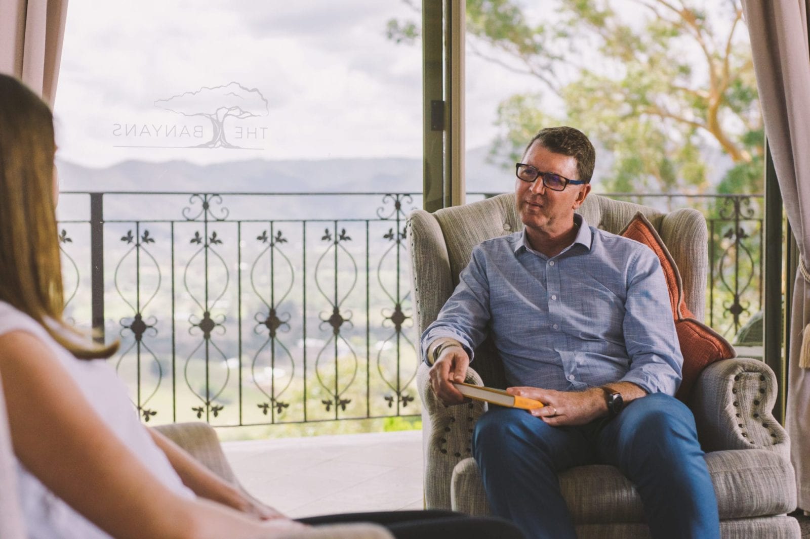woman and man sitting on chairs talking