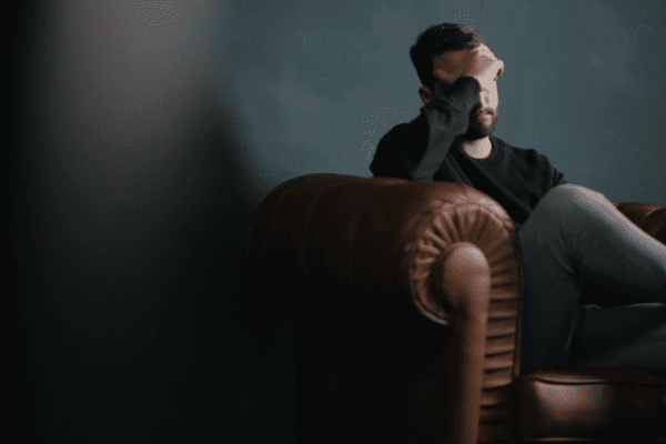 A man sitting with his hand on his face