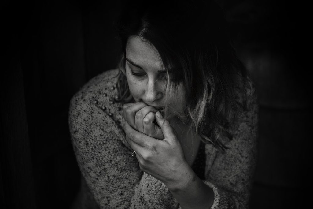 Image of an anxious woman showing signs of anxiety