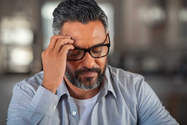 A man with glasses suffering from anxiety