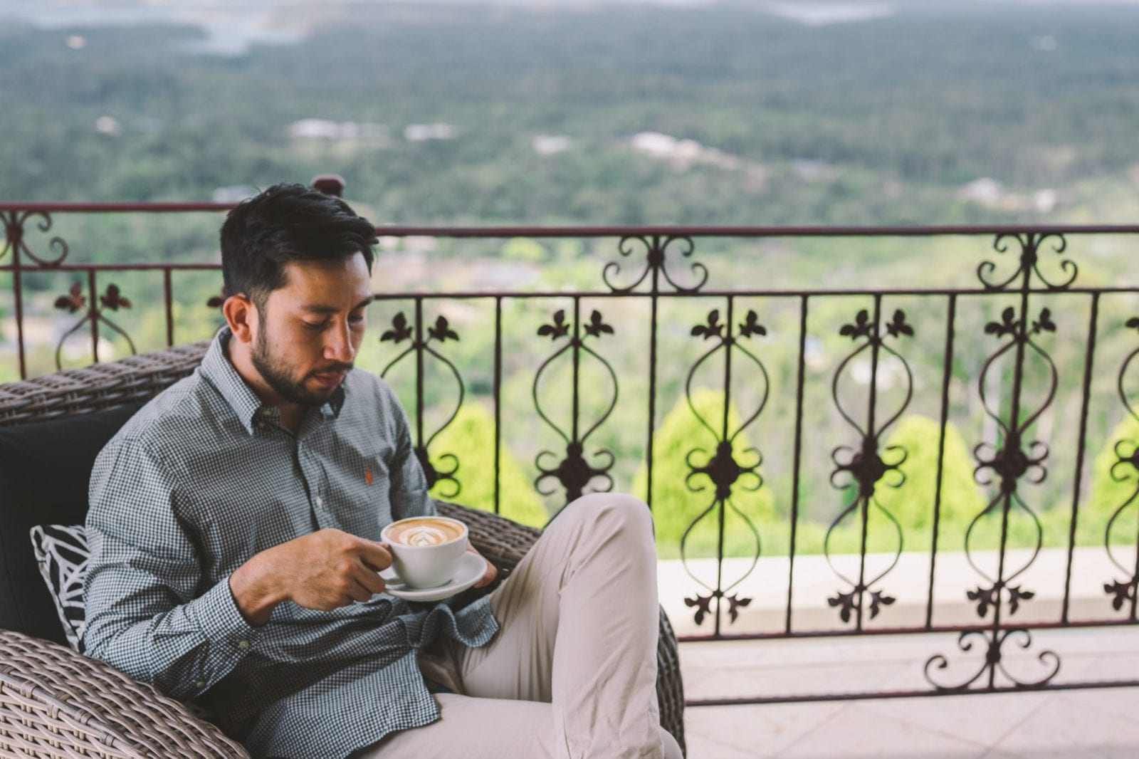 man drinking coffee on balcony