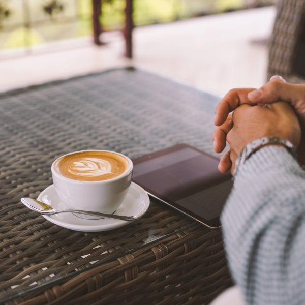 A man with a cup of coffee and his tablet
