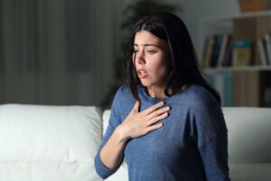 A woman with a hand on her chest experiencing an anxiety attack and wondering - do I have anxiety?