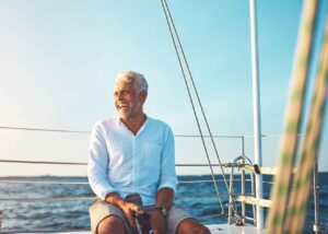 A mature man on a yacht smiling