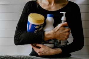 woman holding cleaning products